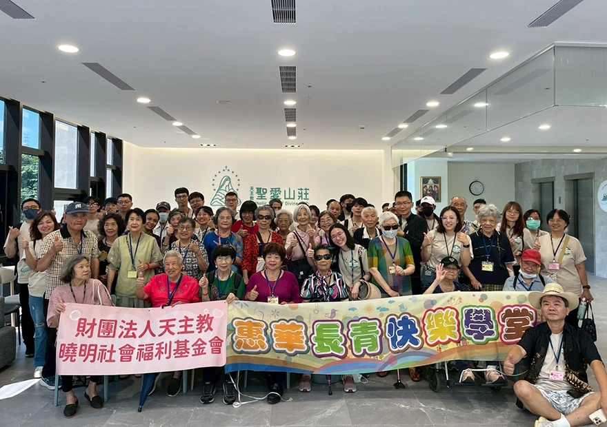 志工和參加活動的長輩們拉著布條大合照
