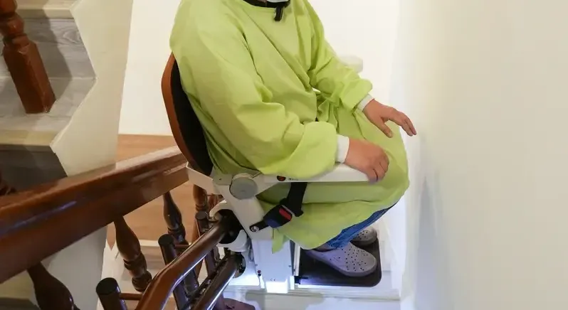 使用者乘坐樓梯升降椅通過狹窄樓梯